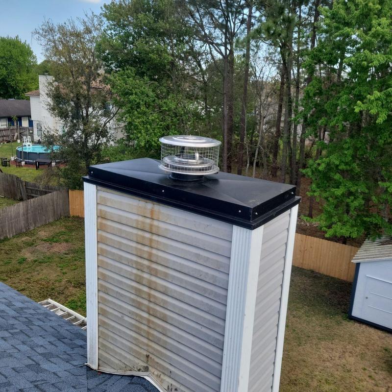 Chimney cap and Owens Corning roof installation in backyard