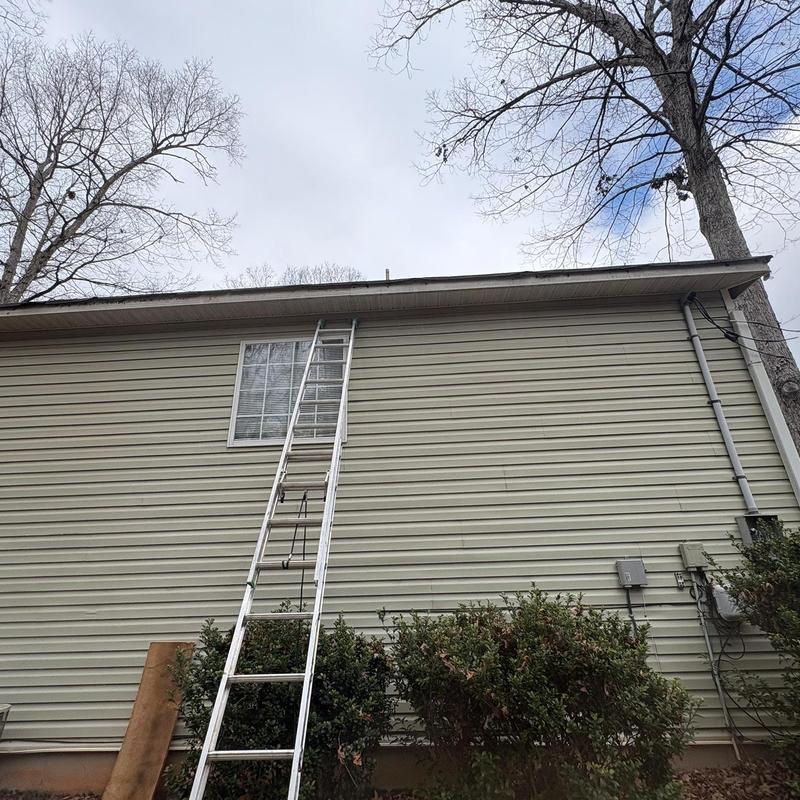 Metal fascia and gutters with ladder setup on house exterior