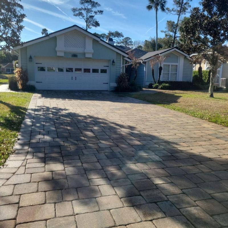 Paver driveway with residential home in background
