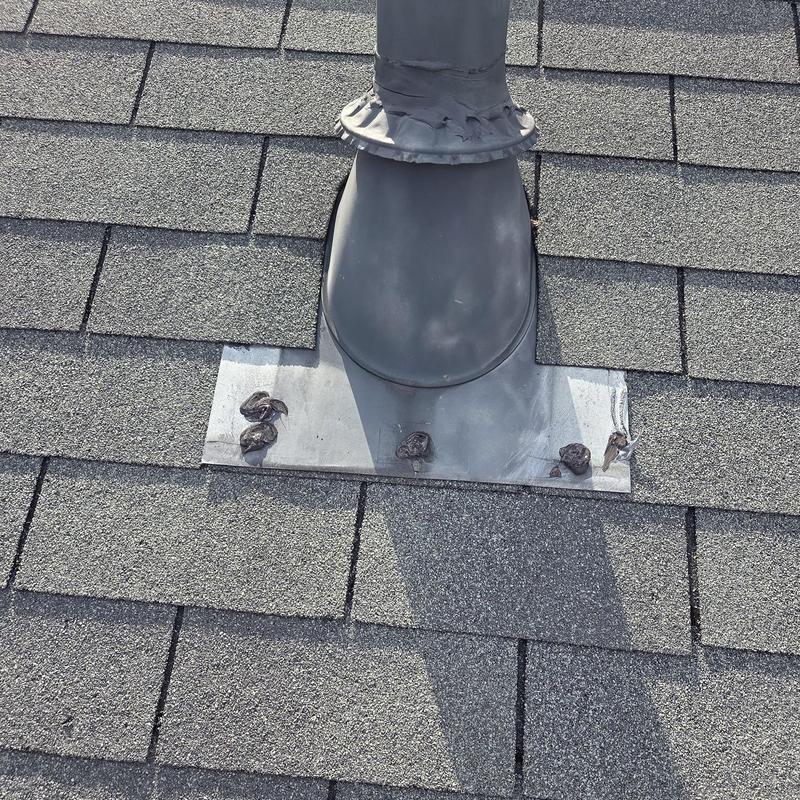 Roof vent flashing with caulked sealant on shingles