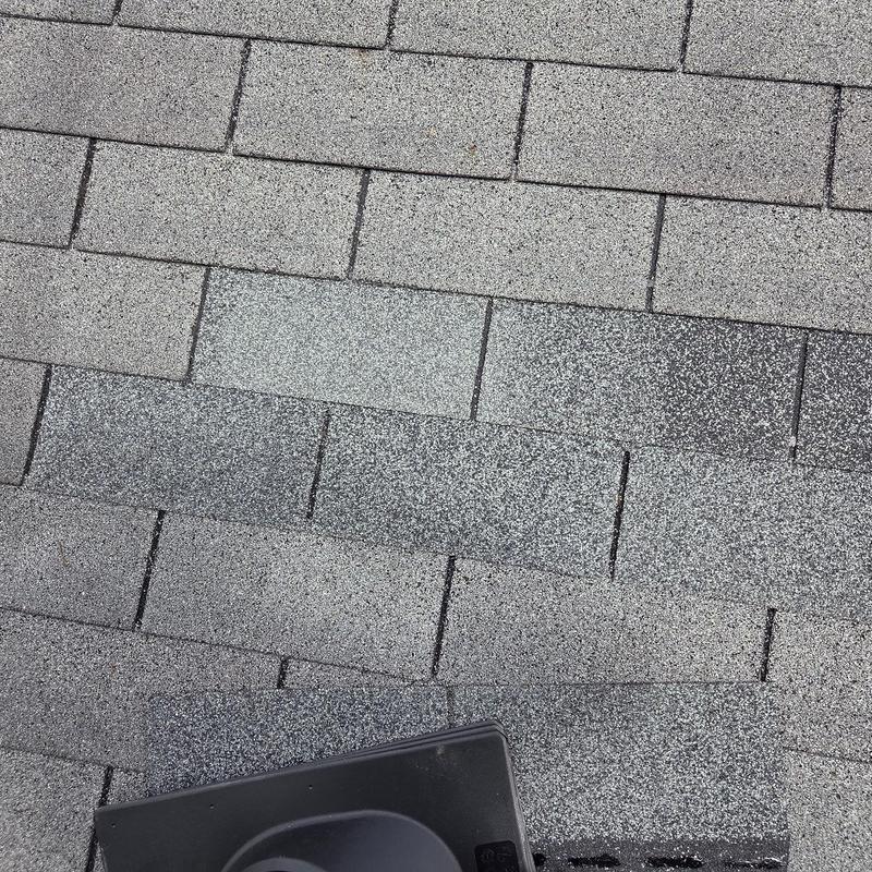 Shingles and black pipe boot on gray asphalt roof