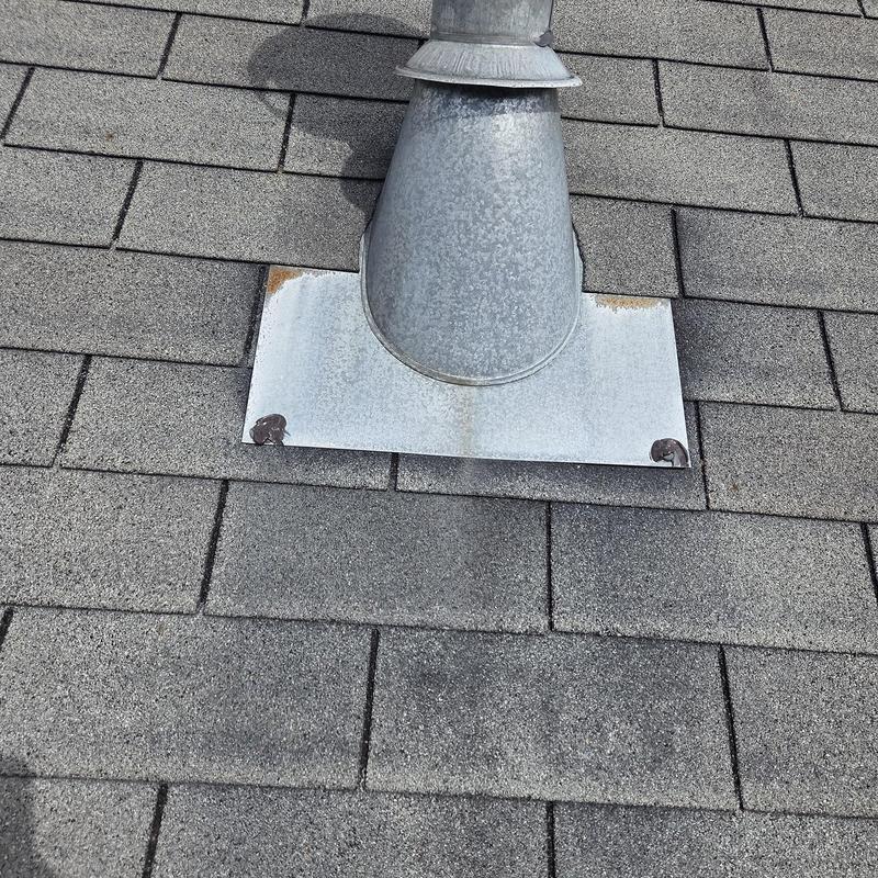 Metal pipe boot on asphalt shingle roof with caulking