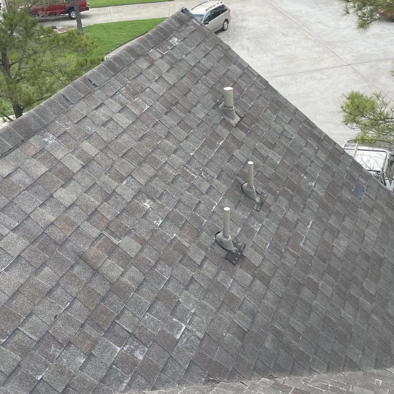 Asphalt shingle roof with weather damage and vent pipes