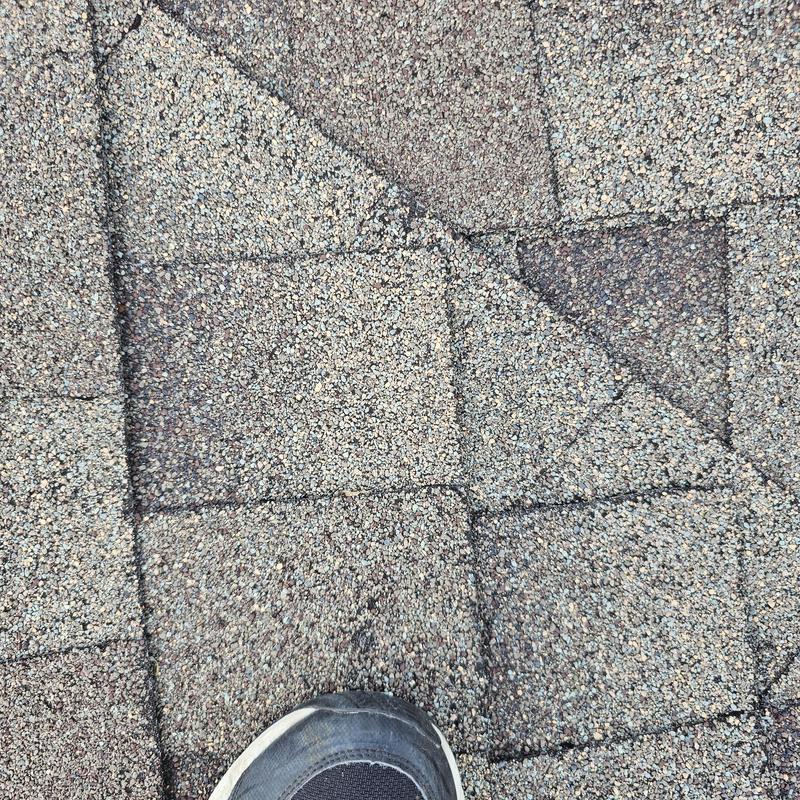 Asphalt roof shingles with hail impact damage close-up