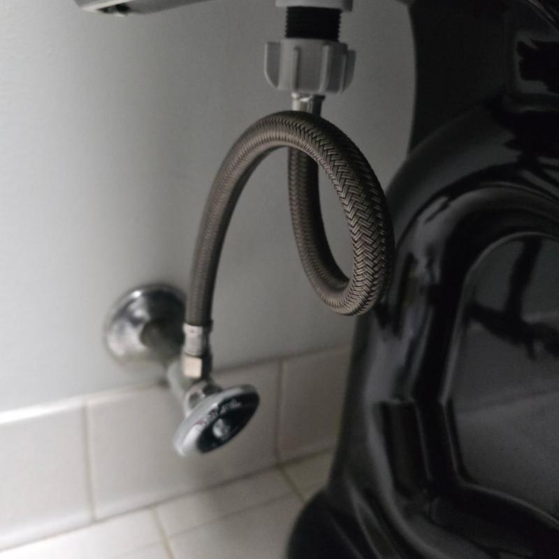 Toilet angle stop valve with braided supply line near vanity