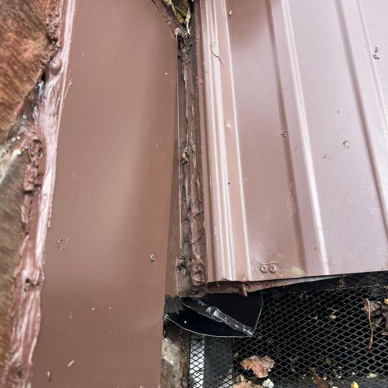 Metal roof flashing with worn sealant and debris buildup