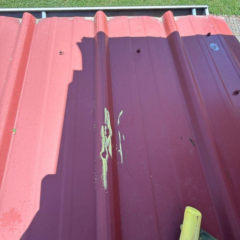 Metal roofing panel with hail damage and paint marks