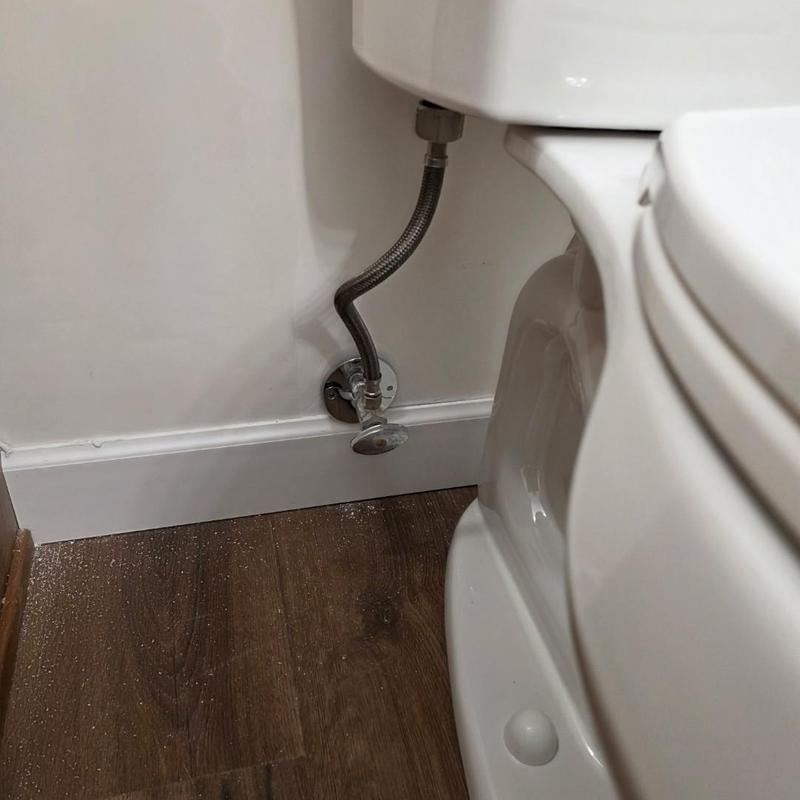 Toilet water supply line installation next to floor trim