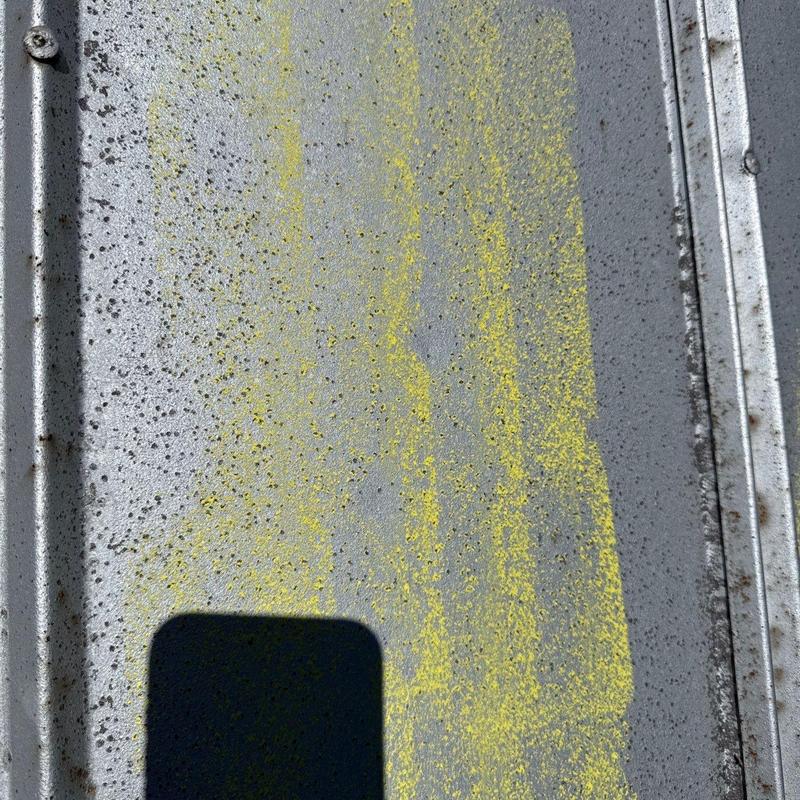 Metal roof panel with yellow hail damage markings