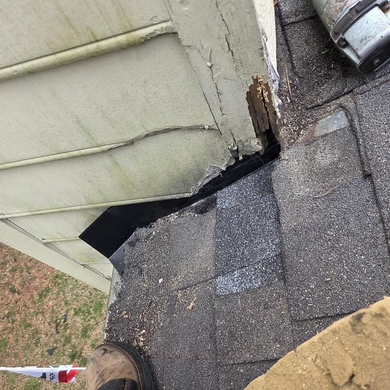 Chimney flashing and roof shingles near vent pipe
