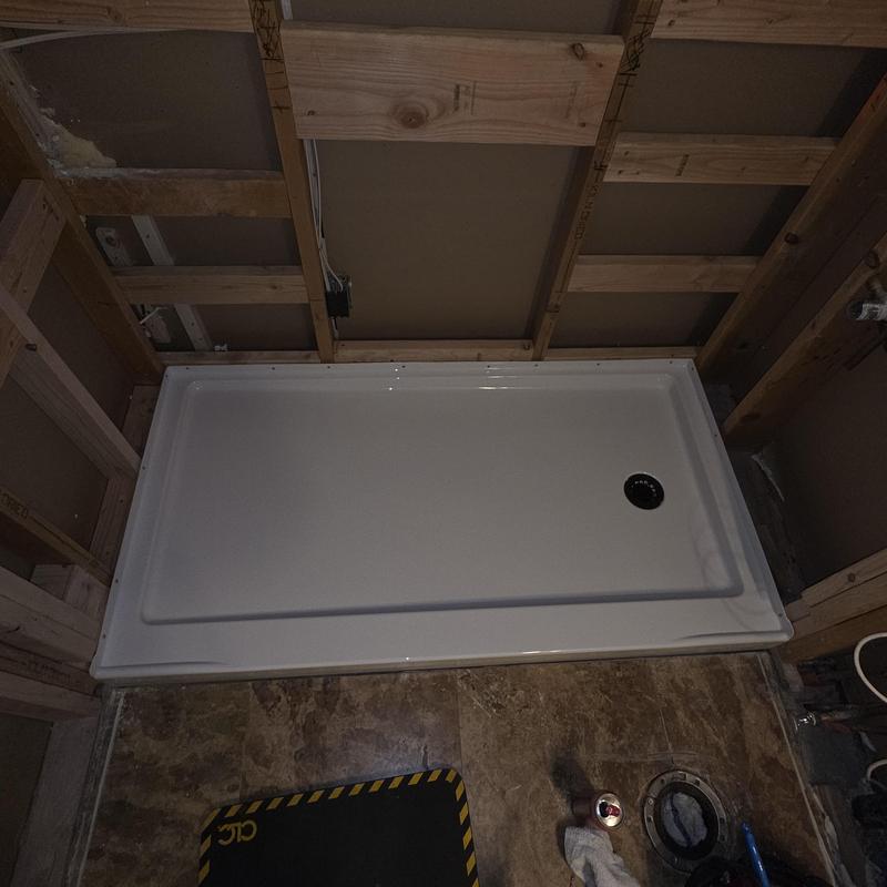 Shower pan installation in wooden frame bathroom