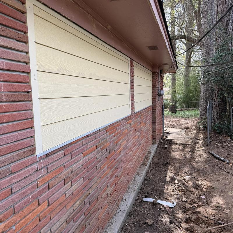 Hardie lap siding installation on brick wall