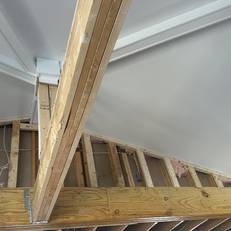 Roofline framing with exposed wooden beams and studs Roofline framing with exposed wooden beams and studs