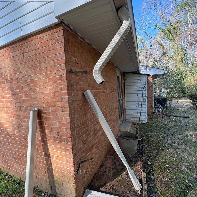 Downspout replacement on brick house corner exterior