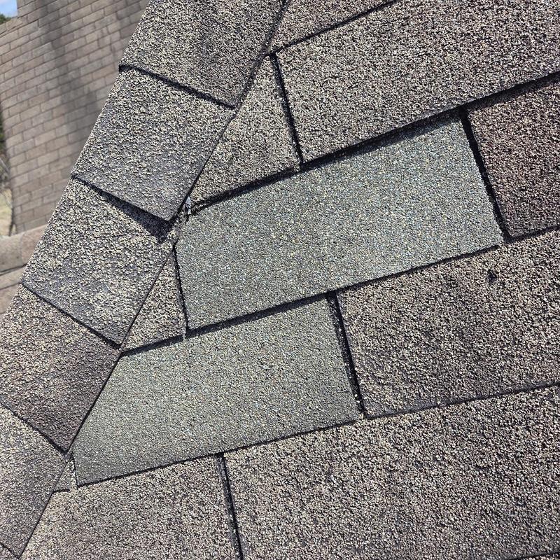 Roof shingles close-up showing replacement section