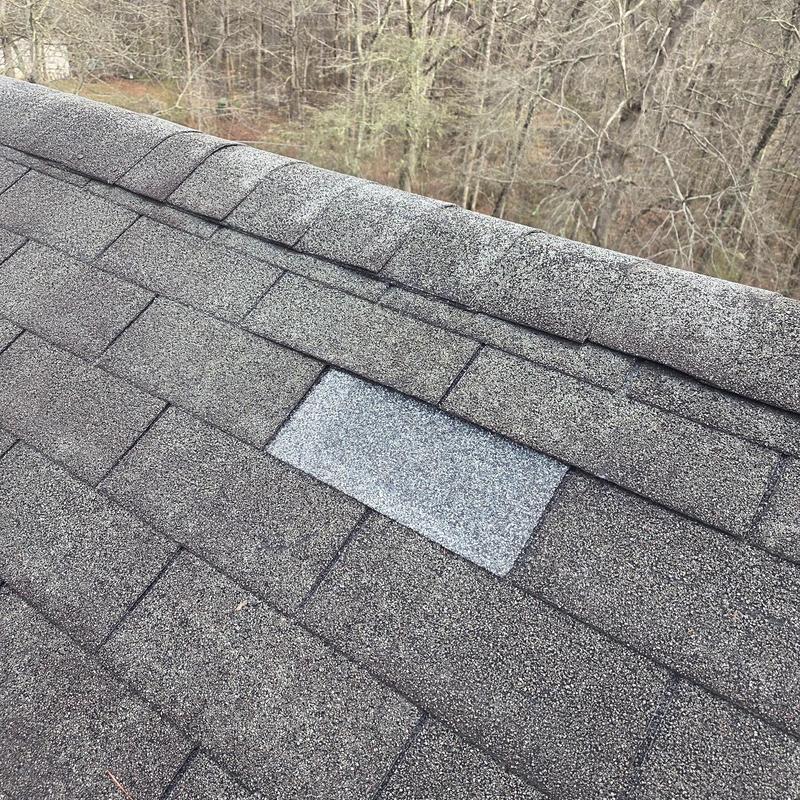 Asphalt shingle roof with a replaced shingle section
