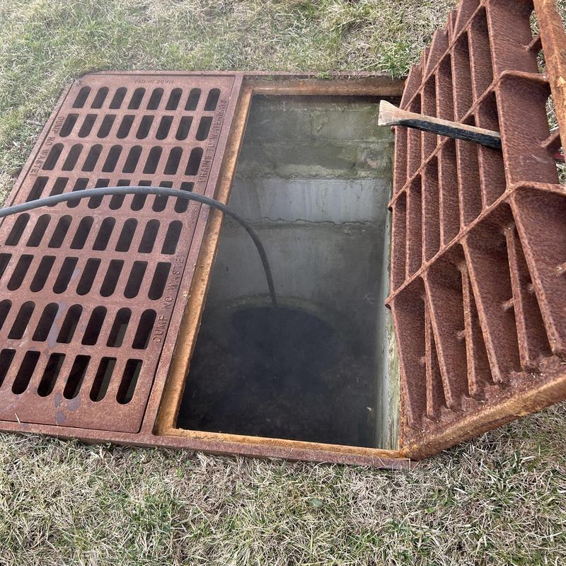 Storm drain jetting with hose in open grate pit