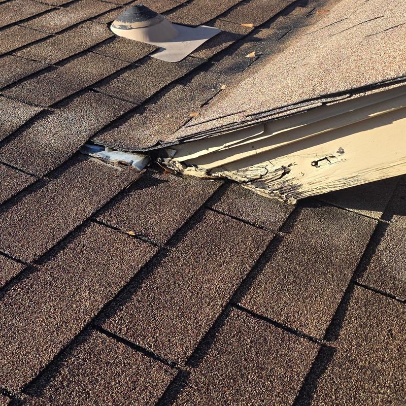 Roof shingles and damaged flashing near vent pipe