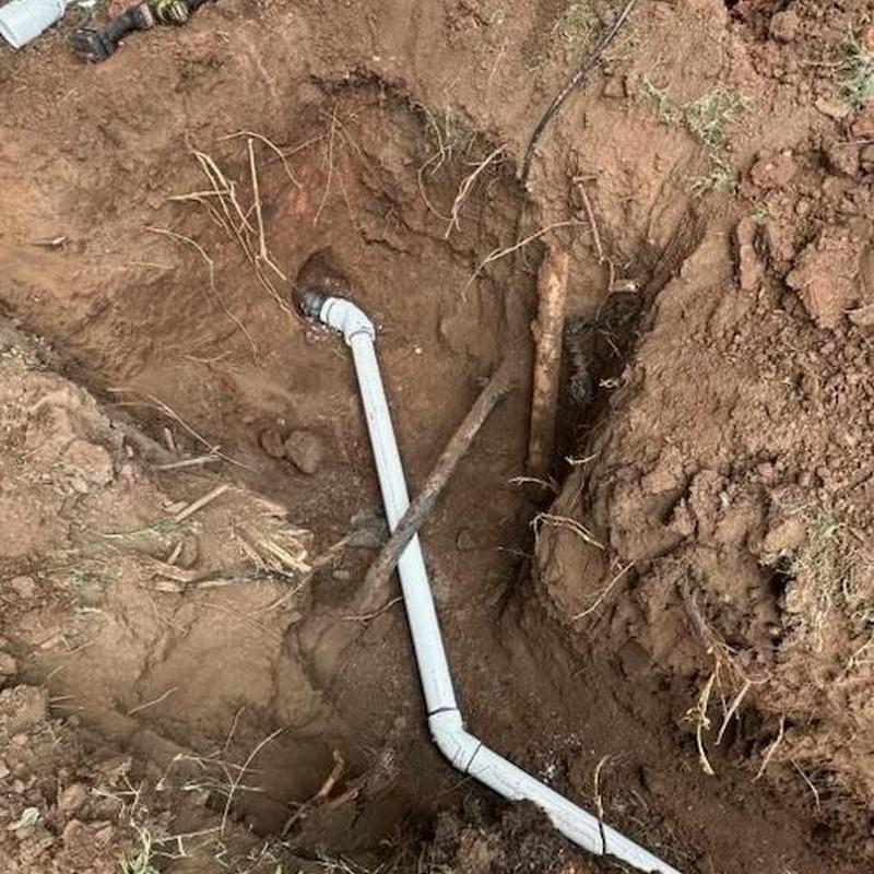 PVC sewer pipe installation in dirt trench
