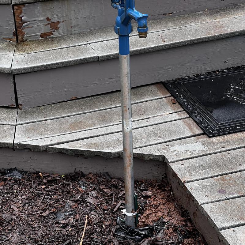 Bury hydrant with blue faucet near porch steps