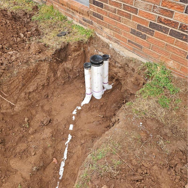 New PVC sewer service line installation near foundation wall