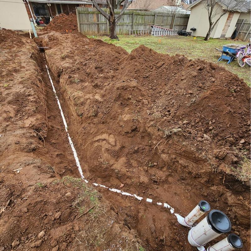 Sewer service line installation in residential backyard trench