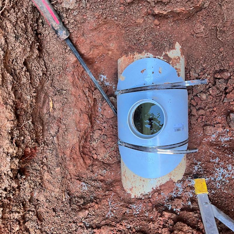 Sewer service line pipe fitting in excavation site