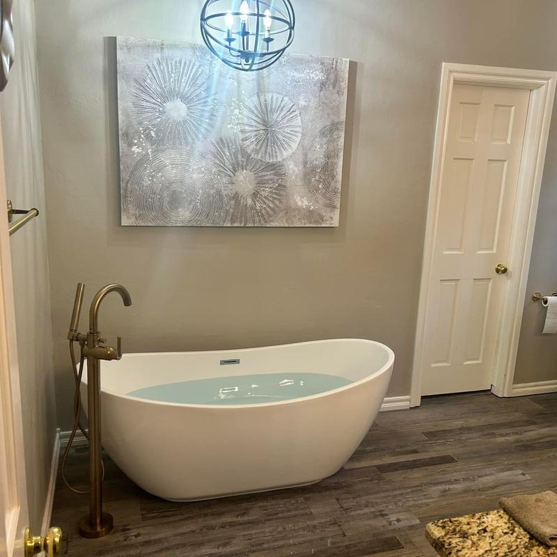 Freestanding bathtub with floor-mounted faucet in bathroom