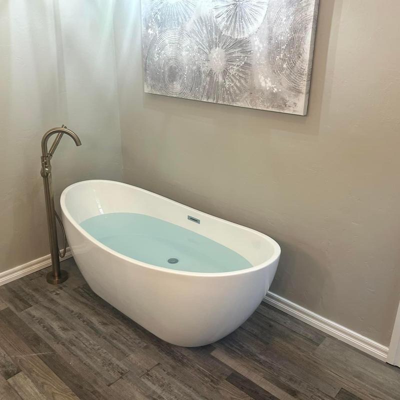 Freestanding bathtub with floor-mounted faucet in bathroom