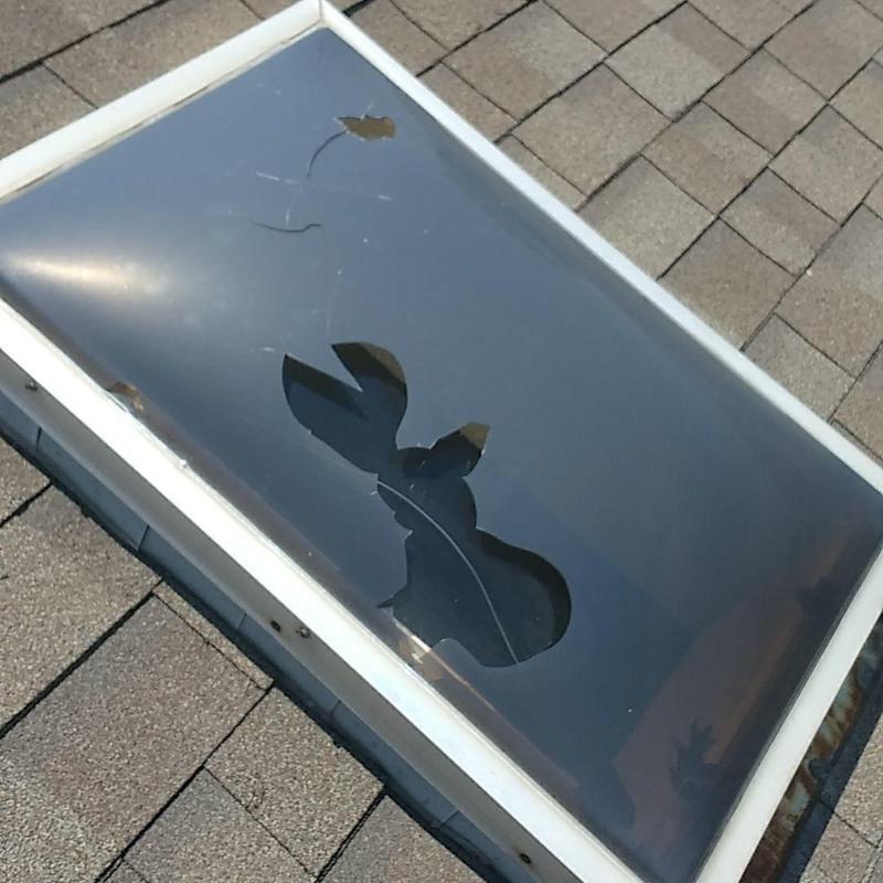 Skylight with cracked glass on shingle roof