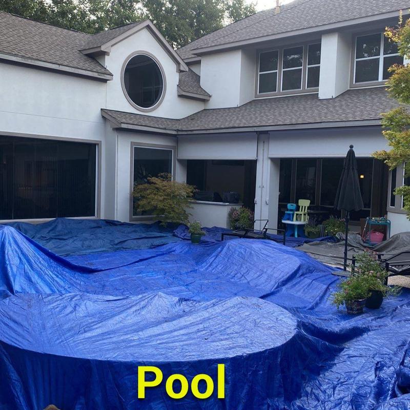 Pool covered with blue tarp in backyard patio area Pool covered with blue tarp in backyard patio area