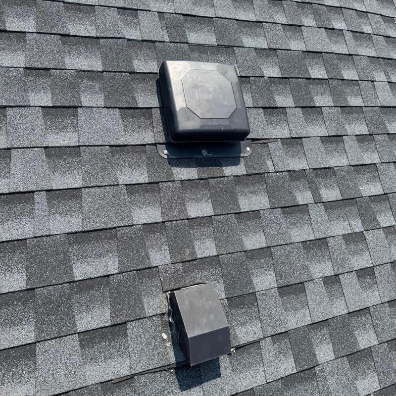 Roof shingles with vent covers on gray asphalt roof