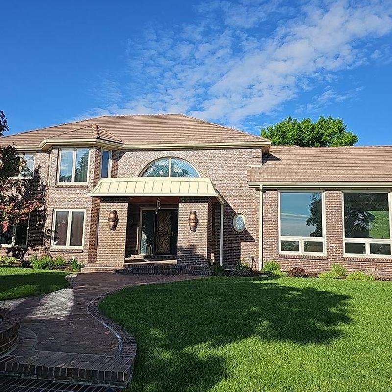 Tile roof with brown tiles over brick house exterior Tile roof with brown tiles over brick house exterior