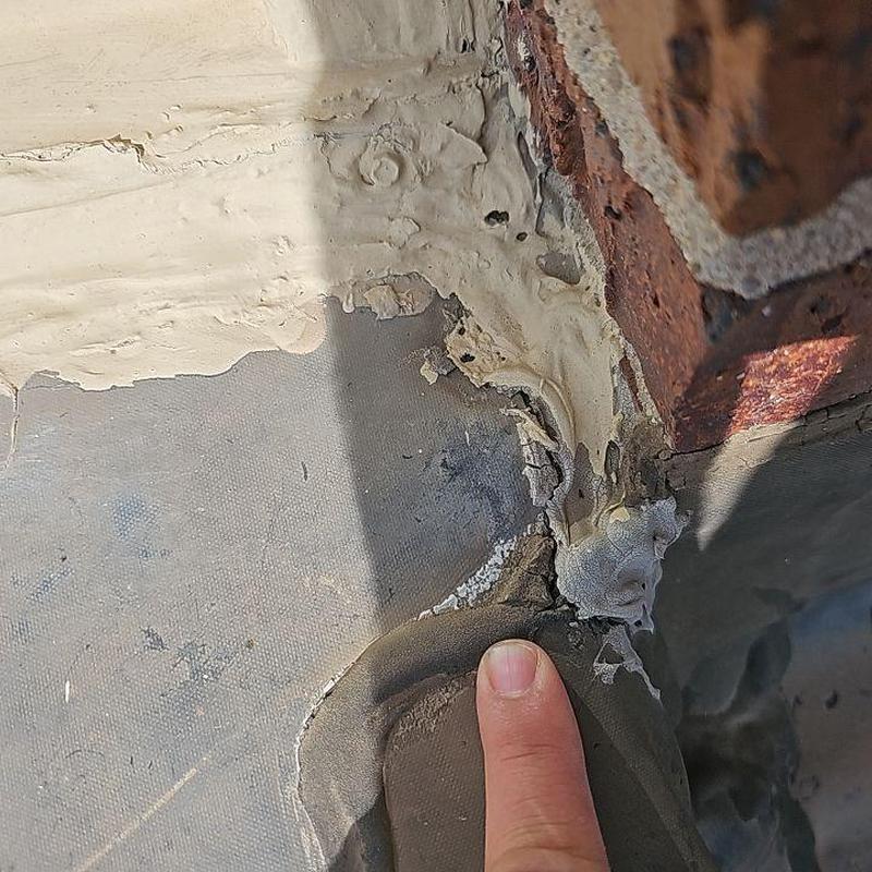 Roof flashing with damaged sealant near brick wall Roof flashing with damaged sealant near brick wall