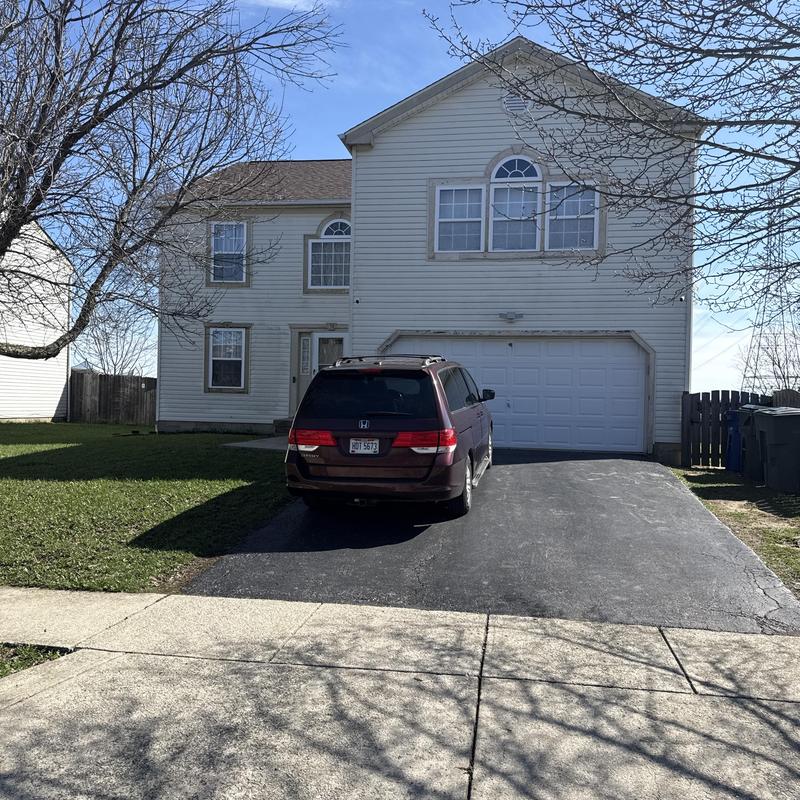 Gutter system on two-story white house with van Gutter system on two-story white house with van