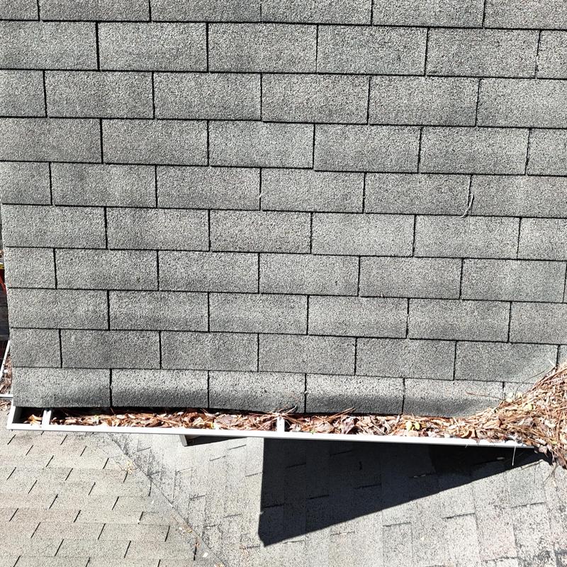 Gutters filled with leaves needing cleaning on roof edge