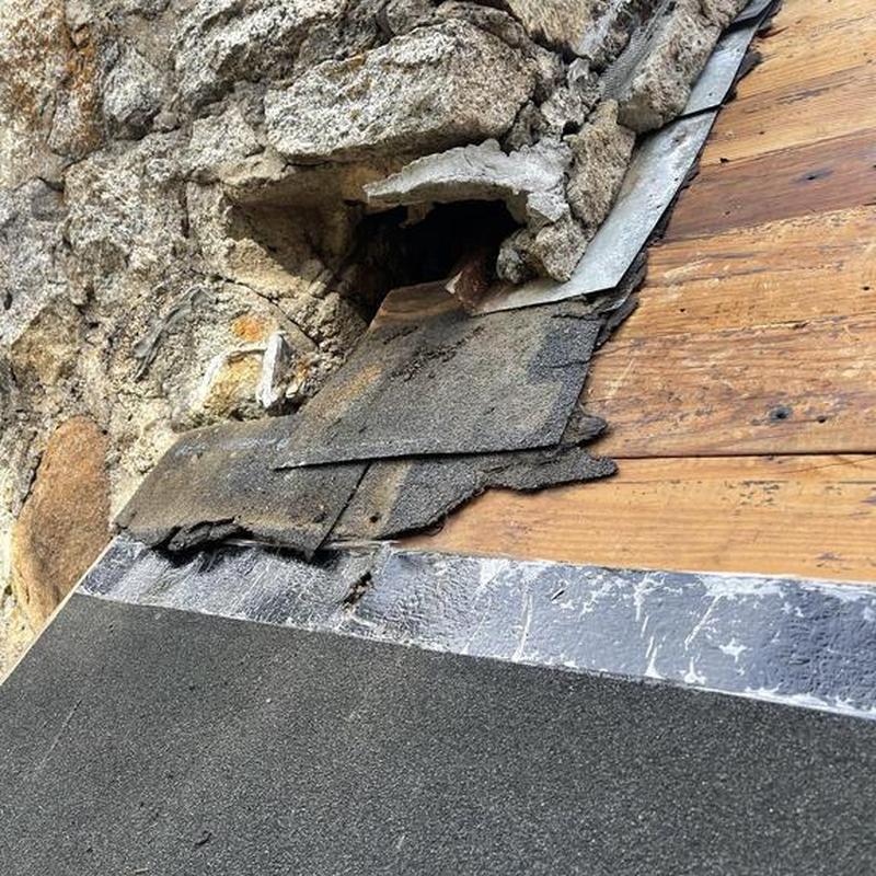 Roof underlayment removal near stone chimney edge