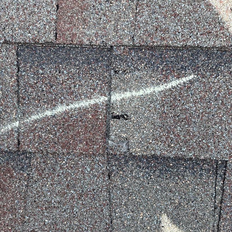 Roof shingles with marked hail damage on surface