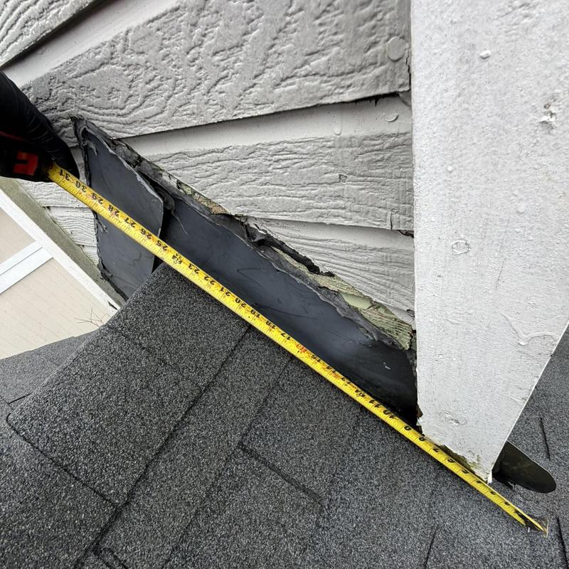 Chimney flashing with measuring tape on roof edge