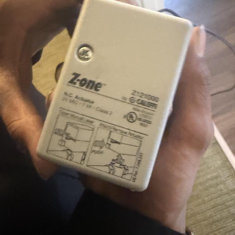 Zone control module held in hands during HVAC inspection