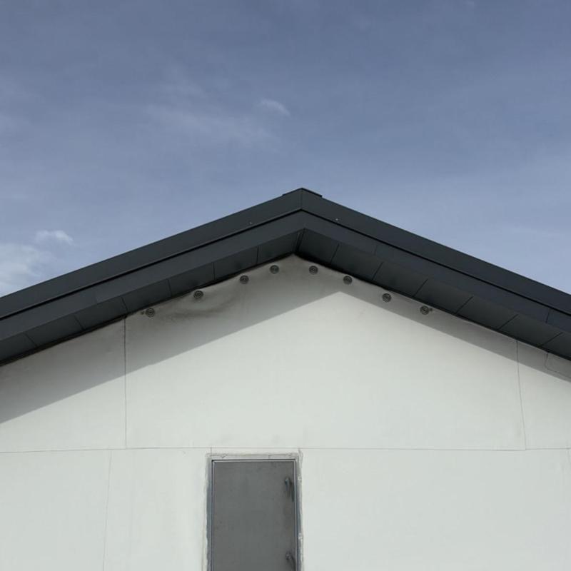 TPO commercial roof edge and wall junction under clear sky