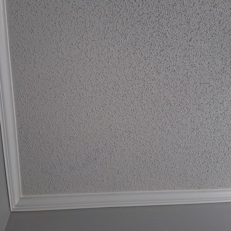 Popcorn ceiling with painted stained area near trim
