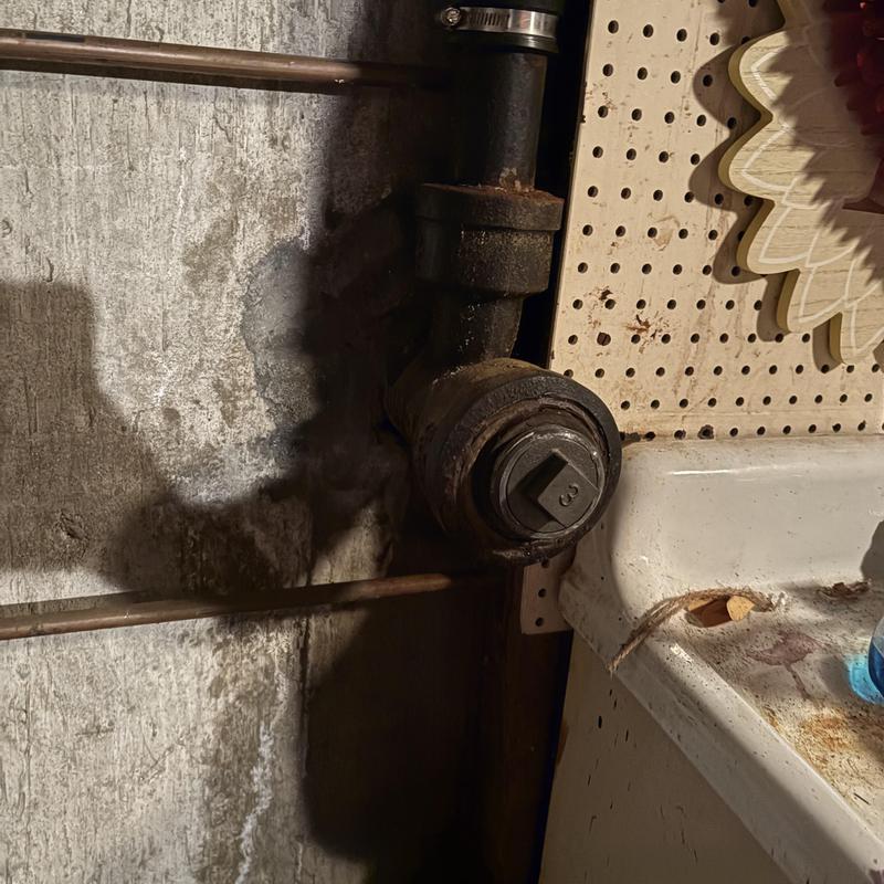 Cast iron sink drain pipe at foundation wall