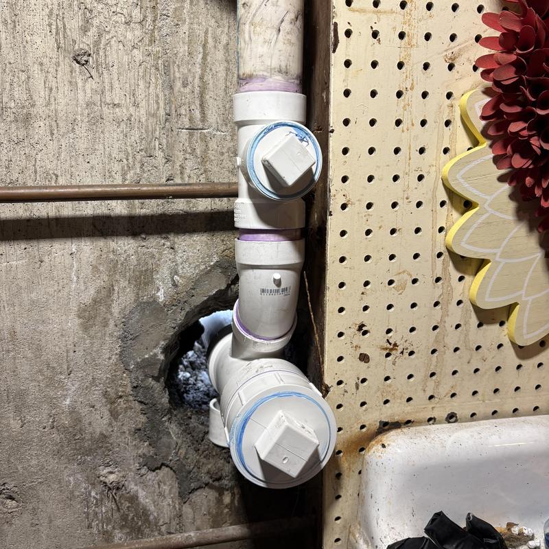PVC sink drain pipe with cleanouts near foundation wall