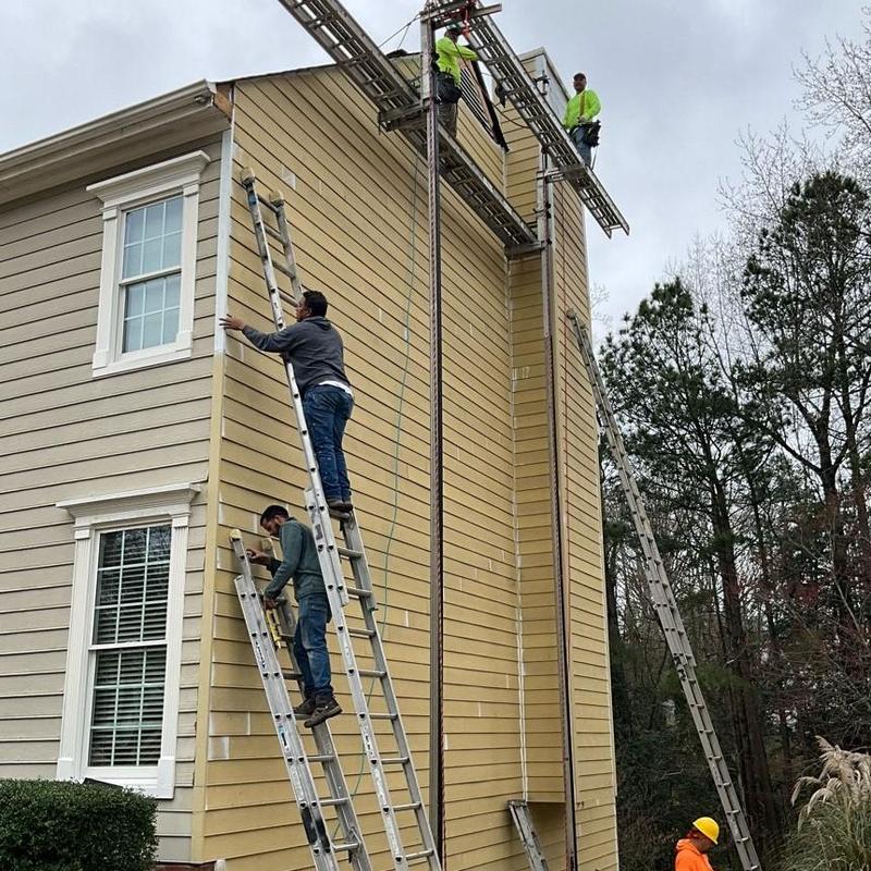 Exterior siding installation with workers on ladders Exterior siding installation with workers on ladders
