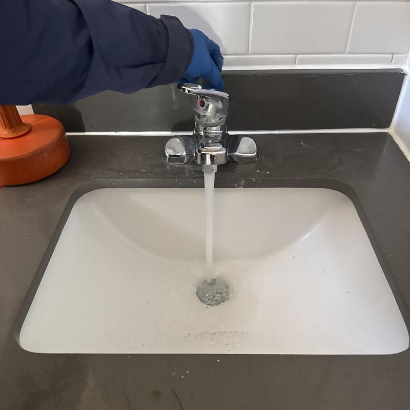 Basin drain clearing with hand crank and flowing water