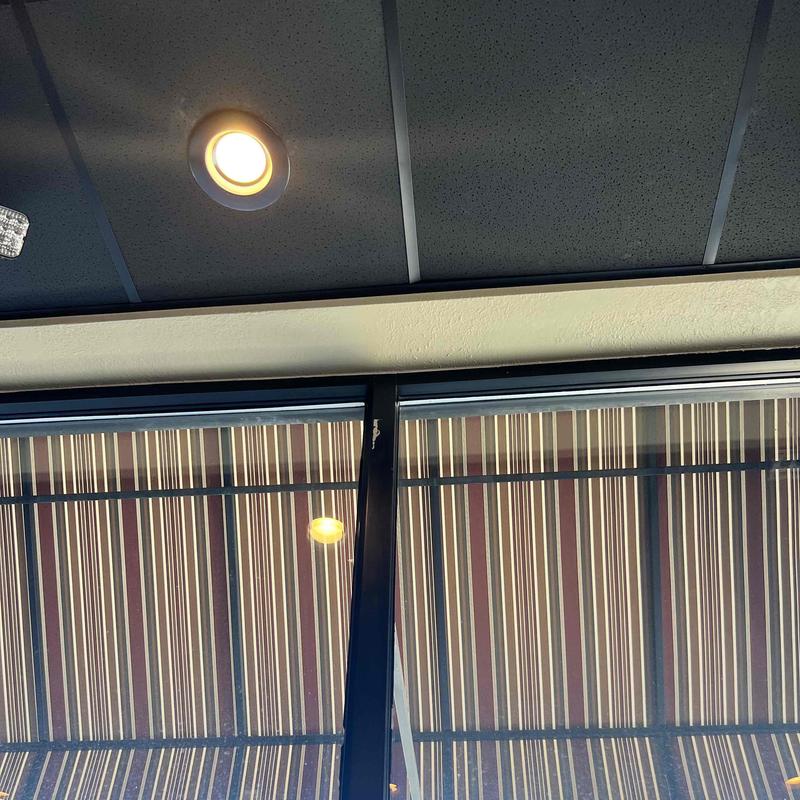 Striped outdoor awning above restaurant window and ceiling light