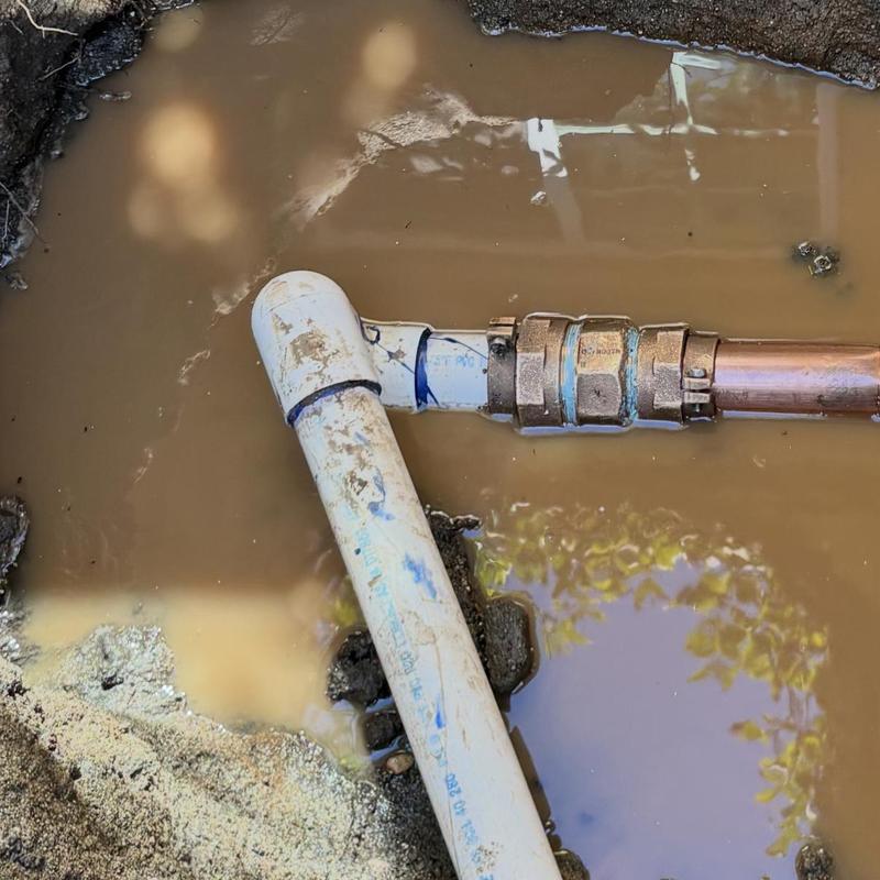 2-inch water main with coupling repair in muddy hole
