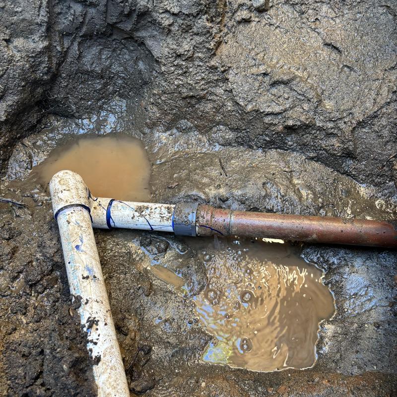 2-inch water main pipe leak in muddy trench