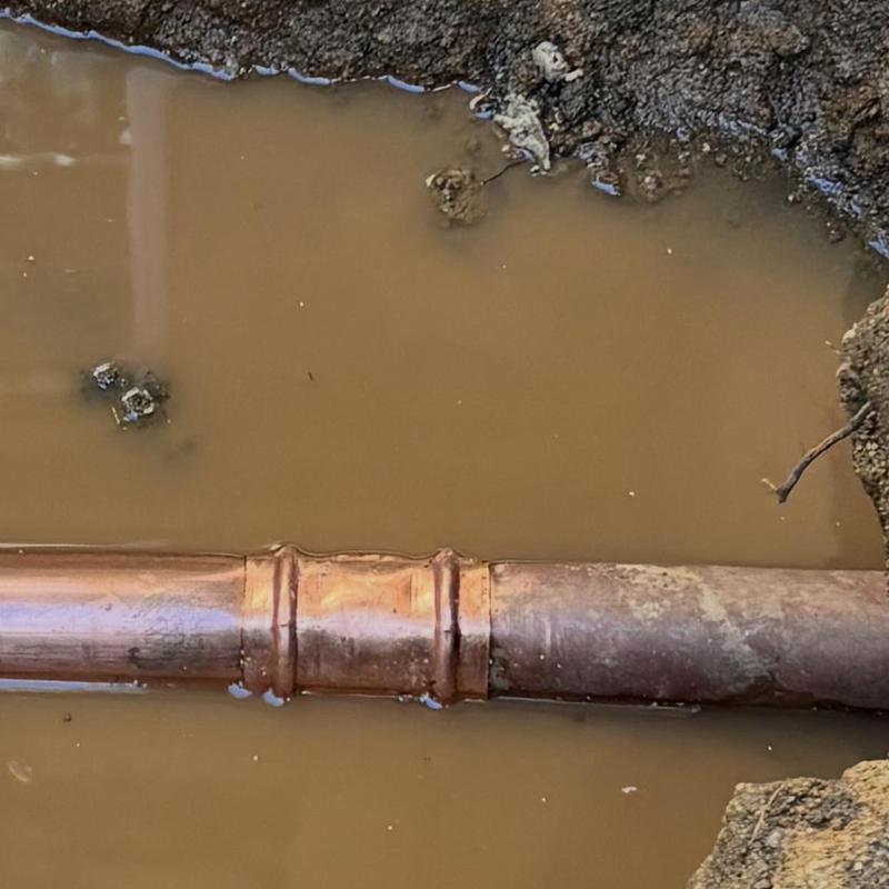 2-inch copper water main in muddy trench